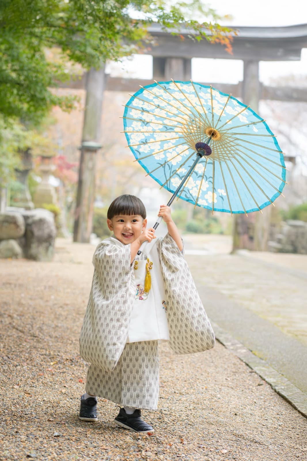 七五三の出張撮影。神社の参道で和傘を持つ子ども
